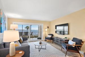 een woonkamer met een bank en een tv bij Coquina Moorings 203 in Bradenton Beach