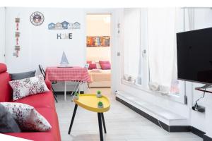 un soggiorno con divano rosso e tavolo giallo di la casa di gusto a La Spezia
