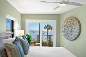 een slaapkamer met een bed en uitzicht op de oceaan bij Coquina Moorings 203 in Bradenton Beach +54 foto's