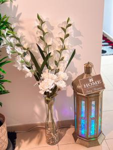 un vase avec des fleurs et une bougie à côté d'une table dans l'établissement The Female Journey Hostel - JBR, à Dubaï