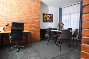 a room with a brick wall and a table and chairs at Spacious and luxury 3 bedroom apartment in Midrand