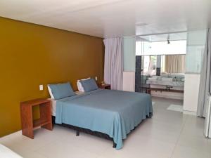1 dormitorio con cama azul y baño en Pousada Corais de Ibiza, en Arraial d'Ajuda