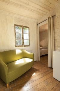 マルティナ・フランカにあるTrulli Valle d'Itriaのベッドルーム1室の客室で、緑のソファが備わります。