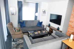 a living room with a couch and a tv at Spacious and luxury 3 bedroom apartment in Midrand