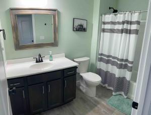 een badkamer met een wastafel, een toilet en een spiegel bij 100 Acre Relaxing Retreat Near Ark- The Woodlands in Williamstown