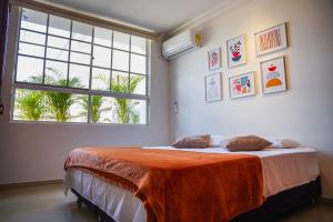 um quarto com uma cama com um cobertor laranja em Apto. para 4 personas en Cali em Cali