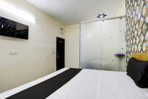 - une chambre avec un lit et une porte coulissante en verre dans l'établissement OYO Flagship Hotel Blue Diamond, à Ghaziabad