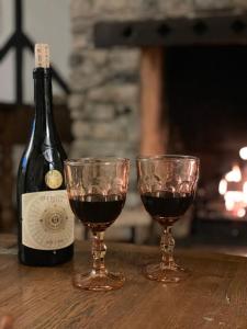 due bicchieri di vino rosso accanto a una bottiglia di vino di Charming 2BR Cottage Retreat in the Centre of Bicester a Bicester