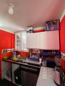 a kitchen with red walls and a counter top at Casa Polska in Paiján