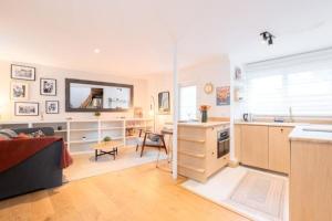 a kitchen and living room with a couch and a table at Lille Citadelle Charming house with courtyard in Lille