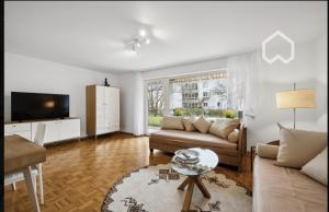 a living room with a couch and a tv at Apartment "Wirtschaftswunder" in Rheinfelden