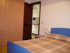 um quarto com uma cama com uma cabeceira azul em Residence Giannella - Pitosforo 46 em Giannella