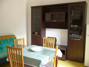 uma sala de jantar com mesa e cadeiras e um armário em Residence Giannella - Pitosforo 46 em Giannella
