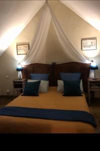 1 dormitorio con 1 cama grande con dosel en Plages du débarquement et bord de mer pour 4 personnes, en Grandcamp-Maisy