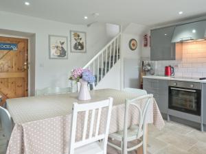a kitchen and dining room with a table and chairs at Brigydon Tresaith in Penbryn