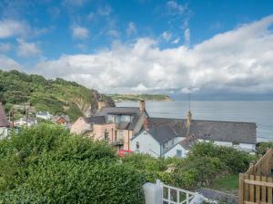 un grupo de casas en una colina junto al océano en Brigydon Tresaith, en Penbryn