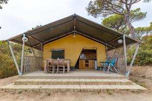 żółty namiot ze stołem i krzesłami w obiekcie Tenuta Delle Ripalte w mieście Capoliveri
