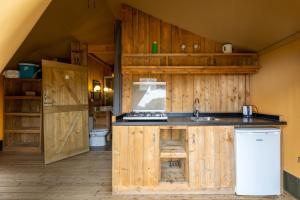 cocina con armarios de madera y lavabo en una habitación en Tenuta Delle Ripalte, en Capoliveri