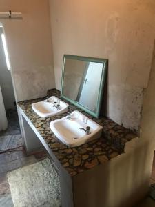 a bathroom with two sinks and a mirror at Dullstroom on the Dam Backpackers in Dullstroom