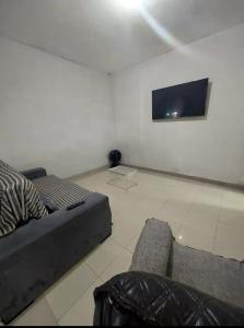 sala de estar con sofá y TV de pantalla plana en Hospedagem do Cabo, en Arraial do Cabo