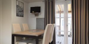 mesa de comedor con sillas blancas y TV en Nosybe37 MH264 Onzain, en Onzain
