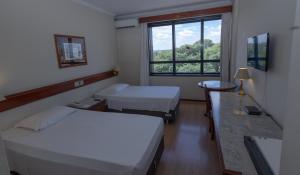 a hospital room with two beds and a window at Lizon Curitiba Hotel in Curitiba +104 photos