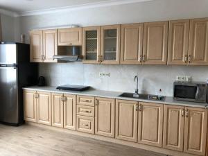 a kitchen with wooden cabinets and a stainless steel refrigerator at У Оксани in Solochyn