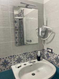 een badkamer met een wastafel en een spiegel bij Oriente Rooms in San Nicola Arcella