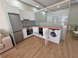a kitchen with a washing machine and a dishwasher at Aquí es in Badajoz