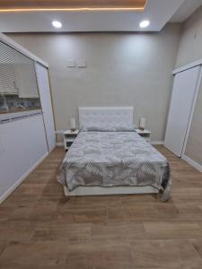 1 dormitorio con 1 cama y 2 mesas. en Aquí es, en Badajoz