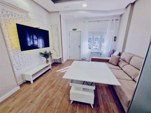a living room with a white table and a couch at Aquí es in Badajoz