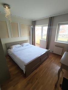 a bedroom with a large bed with white sheets at 塞尔维亚悦客之家民宿 in Belgrade