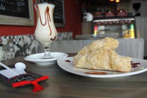 une table avec une assiette de pain et un verre de lait dans l'établissement La Cabrera Hotel Boutique, à Neiva