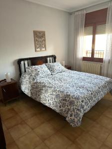Schlafzimmer mit einem Bett mit einer blauen und weißen Bettdecke in der Unterkunft Casa Verilia in Olombrada