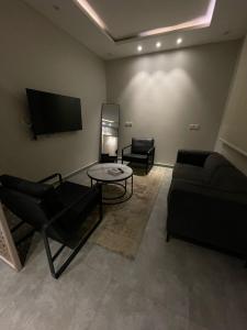 uma sala de estar com um sofá e uma mesa em Arica hotel apartments em Tabuk