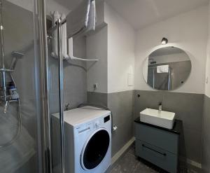 a bathroom with a washing machine and a sink at oompH Warsaw Central 3-bedroom Flat in Warsaw