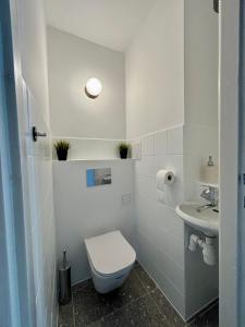 a white bathroom with a toilet and a sink at oompH Warsaw Central 3-bedroom Flat in Warsaw