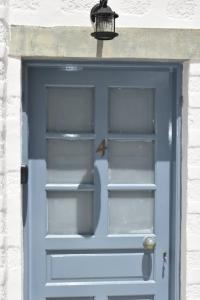 una puerta azul con una luz encima en Patmos Cute Seafront Studio Escape for 2, en Patmos