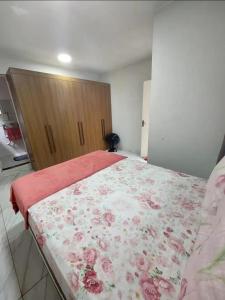 Un dormitorio con una cama grande con una manta de flores en Hospedagem do Cabo, en Arraial do Cabo