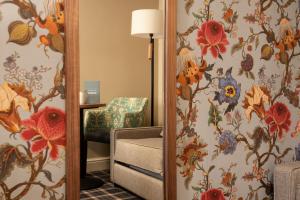um espelho num quarto com papel de parede floral em The Stables - The Inn Collection Group em Whitby