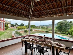 a dining room with a table and chairs and a pool at Finca tres colinas in Lemos