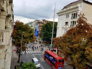un autobús rojo de dos pisos conduciendo por una calle de la ciudad en CS Apartment, en Skopje