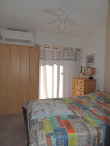 Un dormitorio con una cama y un ventilador de techo. en Petit Paradis a Saint Mandrier 1 chambre plage à 4 mn CLIM Parking Wifi, en Saint-Mandrier-sur-Mer