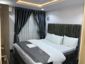 a bedroom with a large bed with white sheets at GREEK VIEW APARTMENT VICTORIA ISLAND in Lagos