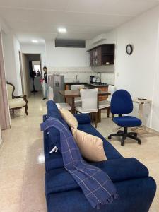 ein Wohnzimmer mit einem blauen Sofa und einer Küche in der Unterkunft apto caney 301 in Cali