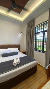 a bedroom with a bed with two towels on it at Eleven25 Roomstay in Dungun