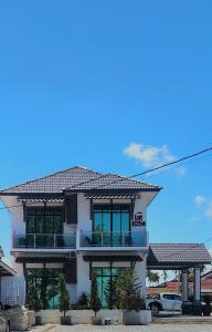 a white building with a balcony on top of it at Eleven25 Roomstay in Dungun