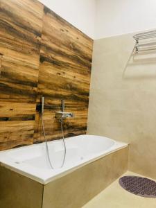 La salle de bains est pourvue d'une baignoire avec un mur en bois. dans l'établissement The Lavish Stay, à Varanasi