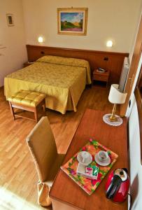 Cette petite chambre comprend un lit et une table. dans l'établissement Hotel Picchio, à Orvieto
