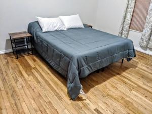 uma cama com um cobertor azul e uma mesa num quarto em Moline 1 BR Near TaxSlayer and Downtown em Moline